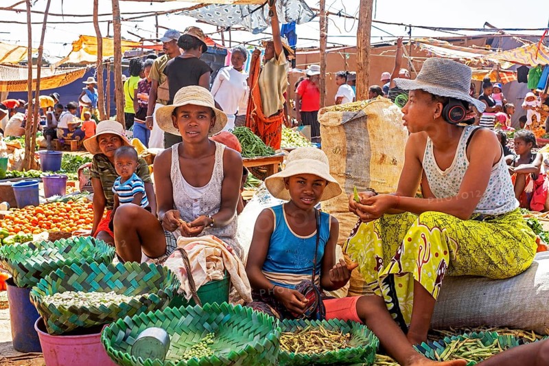 Malagasy girls and children selling fruit and vegetables at food market in the city Ambalavao