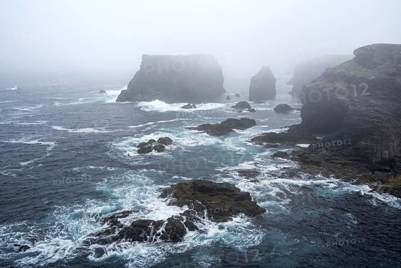 Sea stacks and sea cliffs in mist during stormy weather at Eshaness