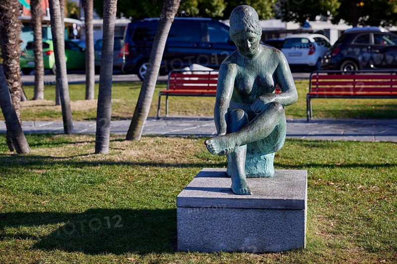 Sculpture of a seated female nude by sculptor Werner J. Mueller on the lakeside promenade of Lake Maggiore in Ascona