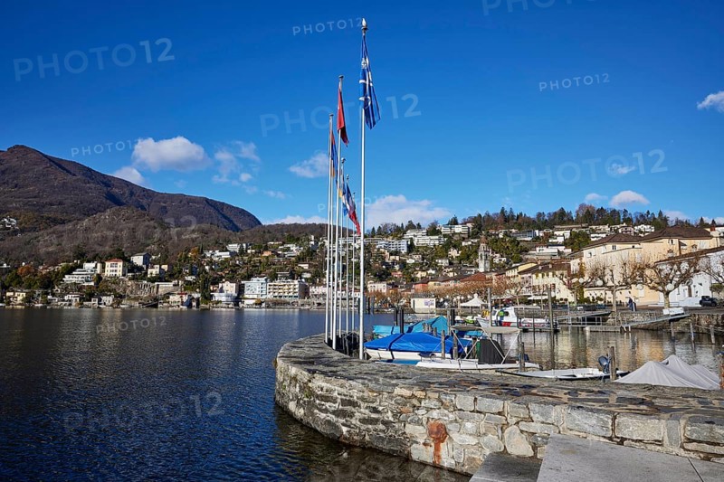 Harbour with flags and stone wall in Ascona