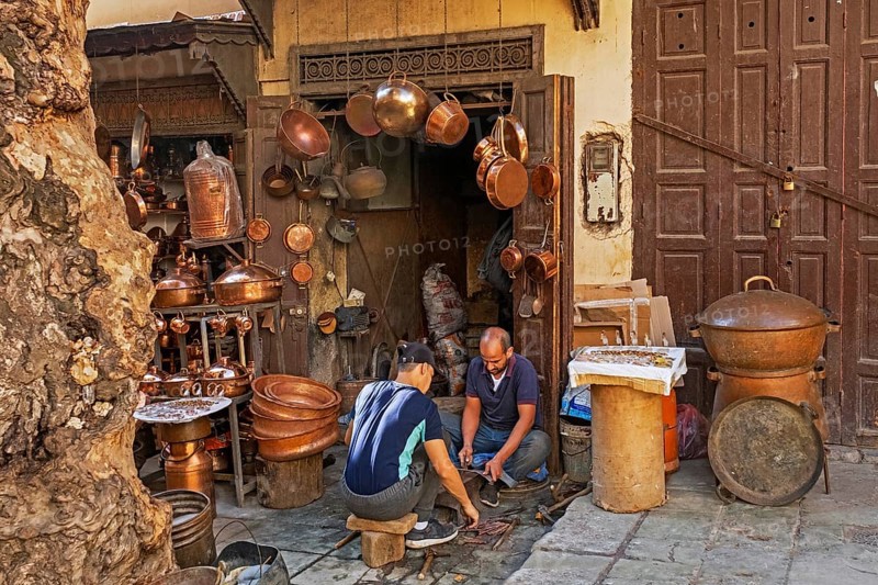 Moroccan coppersmiths working in workshop on Place Seffarine