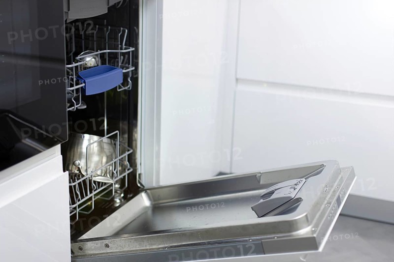 White modern dishwasher in the interior of a white kitchen