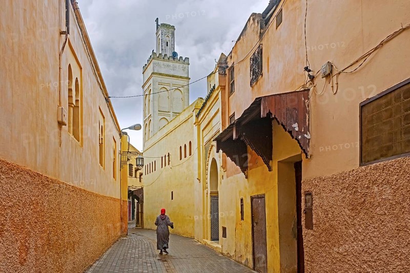 Minaret and Muslim woman wearing djellaba