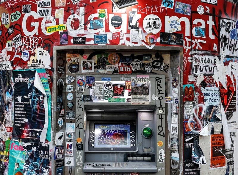 ATM with graffiti and stickers on the RAW site. The RAW site is the former Reichsbahn repair works in the Friedrichshain district. Today