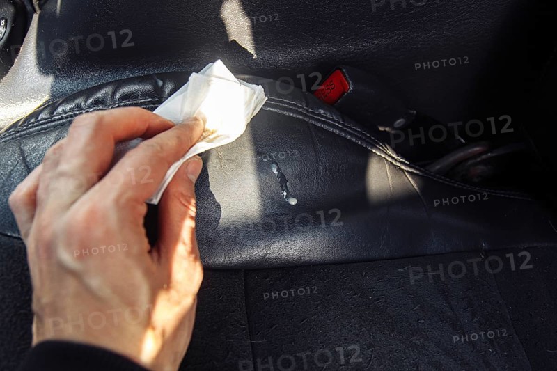The driver cleans the leather interior of the car
