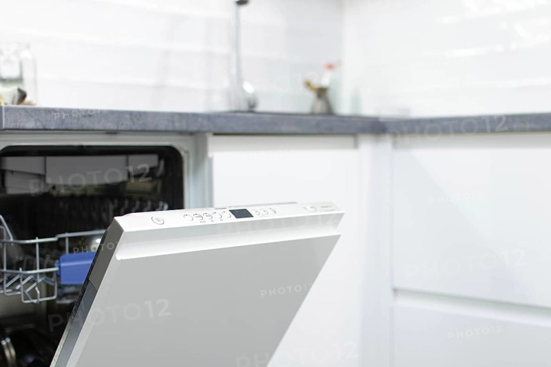 White modern dishwasher in the interior of a white kitchen