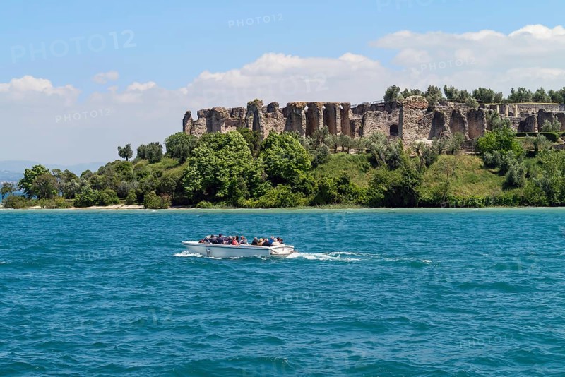 Boat with tourists in front of the Grottoes of Catullus