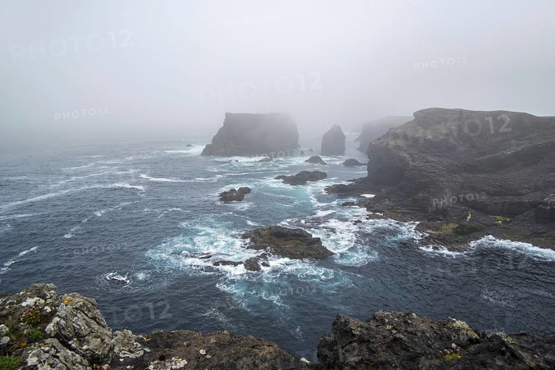 Sea stacks and sea cliffs in mist during stormy weather at Eshaness