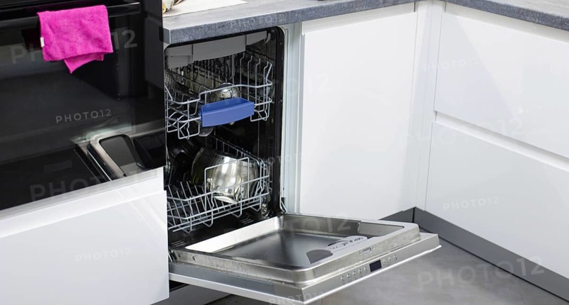 White modern dishwasher in the interior of a white kitchen