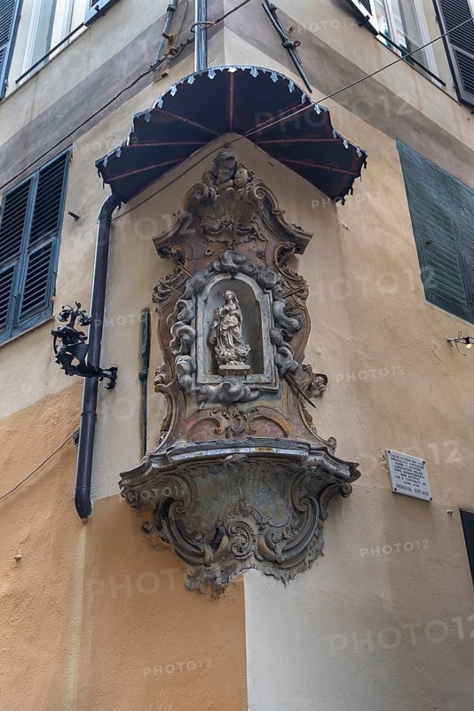 Sculpture of the Virgin Mary under a canopy on a corner house in the historic centre
