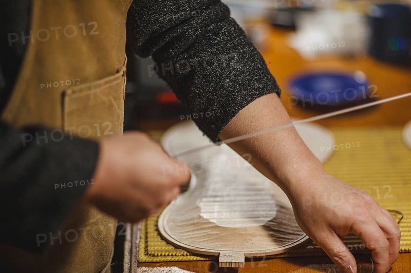 Unrecognizable luthier lute maker artisan both hands performing bend controller purfling strips process in iron tool for a new raw back and front plates of classic handmade violin in his workshop in Cremona