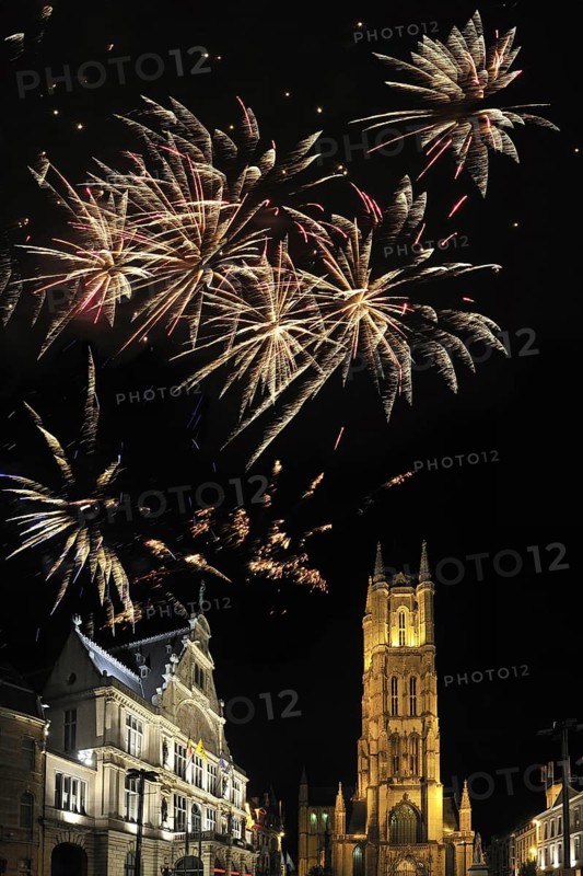 Colourful fireworks above the Saint Bavo's Square with theatre and the Saint Bavo's cathedral at night