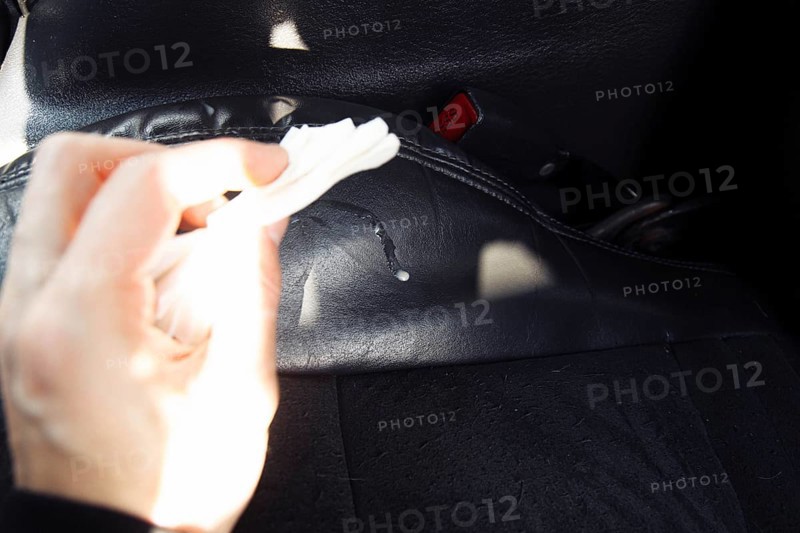 The driver cleans the leather interior of the car