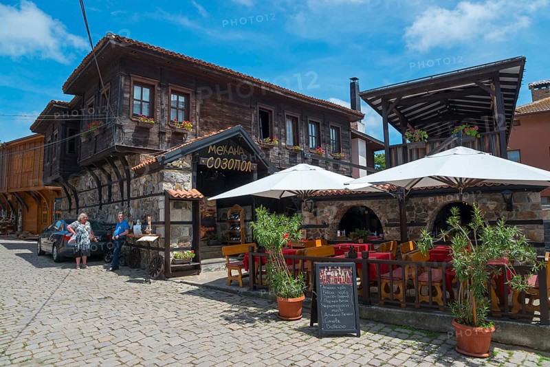 Cosy restaurant in an old town with traditional wooden architecture on a sunny day