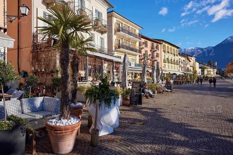 Palm trees in clay pots and outdoor catering and restaurant areas on the Piazza Giuseppe Motta promenade in Ascona