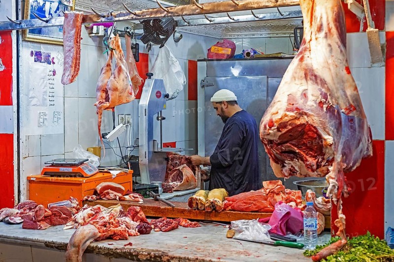 Butcher cutting meat in butcher's shop