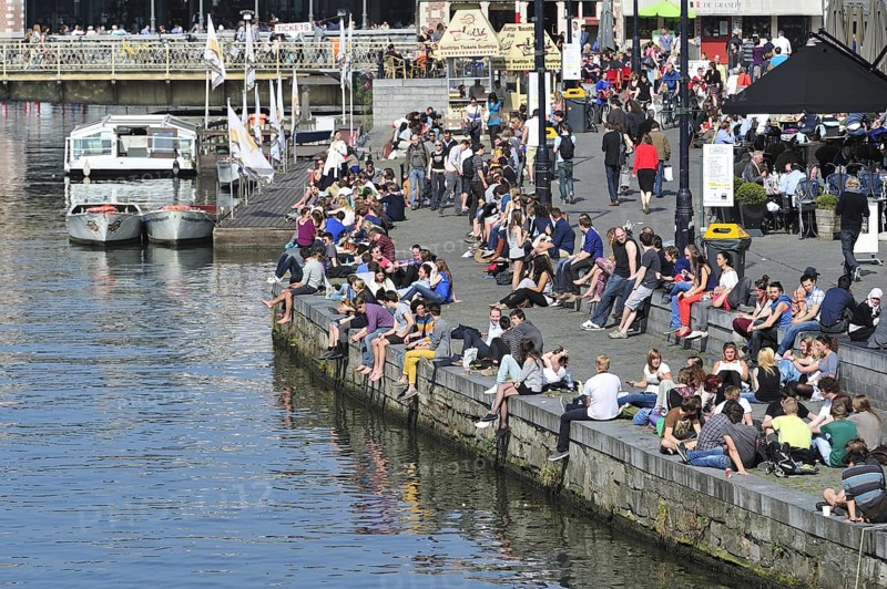 People enjoying the first spring sun by the waterside along the Graslei at Ghent