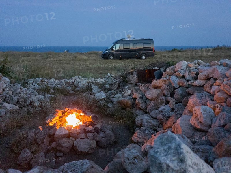 Eternal fire at night with view of motorhome