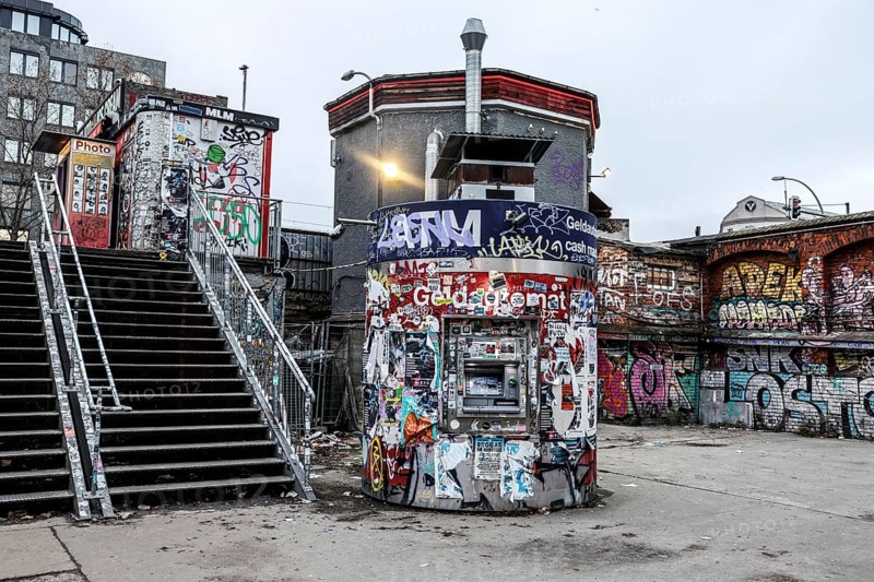 ATM with graffiti and stickers on the RAW site. The RAW site is the former Reichsbahn repair works in the Friedrichshain district. Today