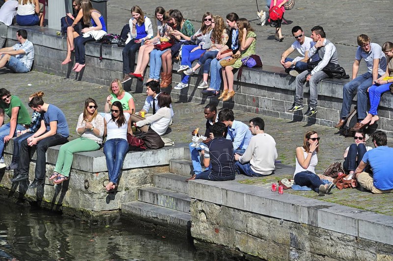 People enjoying the first spring sun by the waterside along the Graslei at Ghent