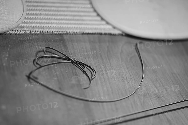 Front and back plates of new raw handmade classic violin on a workbench in violinmaker artisan workshop and purfling fillet made of evony and ivory or pear wood ready to be inserted in the carved all around the shape for aesthetic touch and prevent cracking