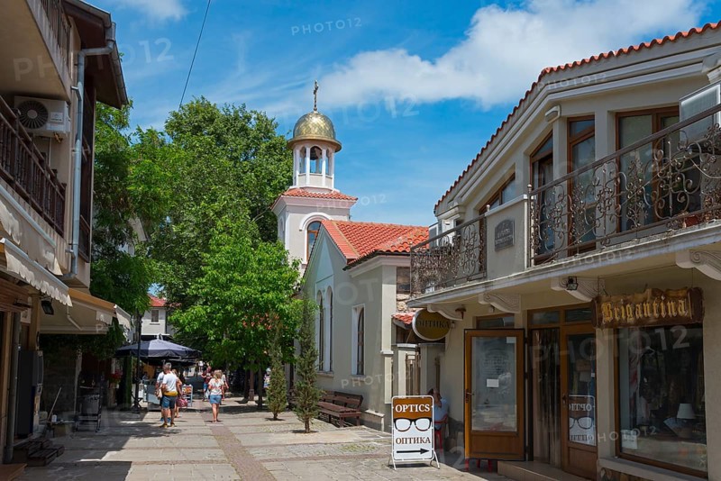 Pedestrian zone with people strolling between shops and a church