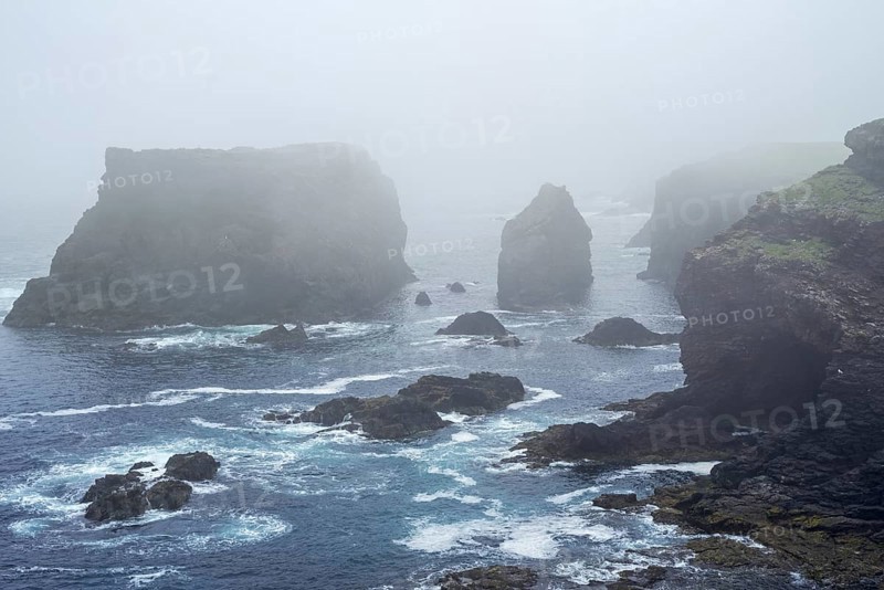 Sea stacks and sea cliffs in mist during stormy weather at Eshaness