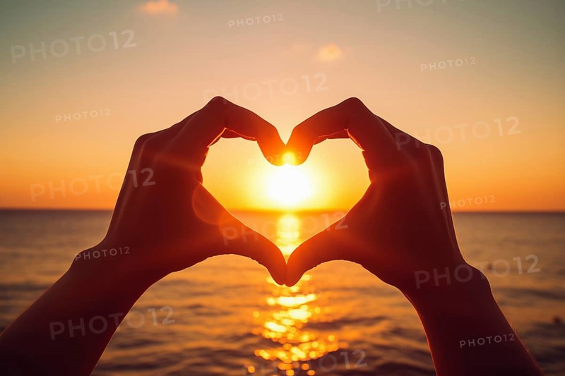 Two hands forming a heart shape, silhouetted against a breathtaking ocean sunset. Love and warmth on Valentine Day or any romantic occasion, AI generated