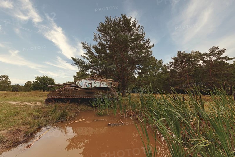 Abandoned tank stands in the middle of nature, silently reflected in the water of a pond, M41 Bulldog, Lost Place, Brander Wald, Aachen, North Rhine-Westphalia, Germany, Europe