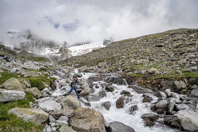 Mountaineers photographed, at a mountain stream, Furtschaglbach, behind rocky mountains with glacier Furtschaglkees, Furtschaglhaus, Berliner Hoehenweg, Zillertal, Tyrol, Austria, Europe