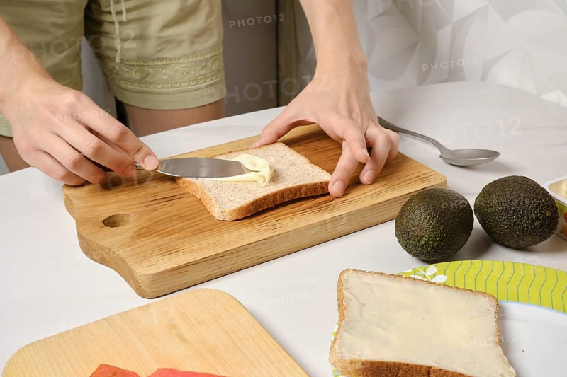 Hands of woman spreading soft cheese on toast