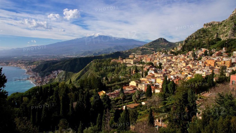 Mount Etna, panoramic view of a coastal town with mountains in the background and clear sky, Taormina, Eastern Sicily, Sicily, Italy, Europe
