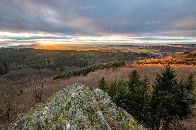 Landscape at the Grosser Zacken, Taunus volcanic region. A cloudy, sunny autumn day, meadows, hills, fields and forests with a view of the sunset. Hesse, Germany, Europe