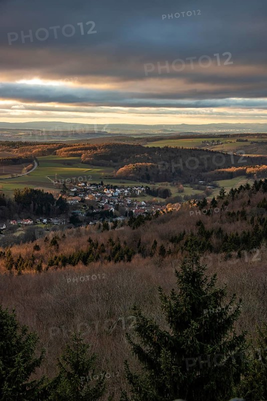 Landscape at the Grosser Zacken, Taunus volcanic region. A cloudy, sunny autumn day, meadows, hills, fields and forests with a view of the sunset. Hesse, Germany, Europe