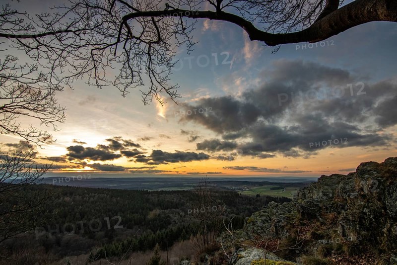Landscape at the Grosser Zacken, Taunus volcanic region. A cloudy, sunny autumn day, meadows, hills, fields and forests with a view of the sunset. Hesse, Germany, Europe