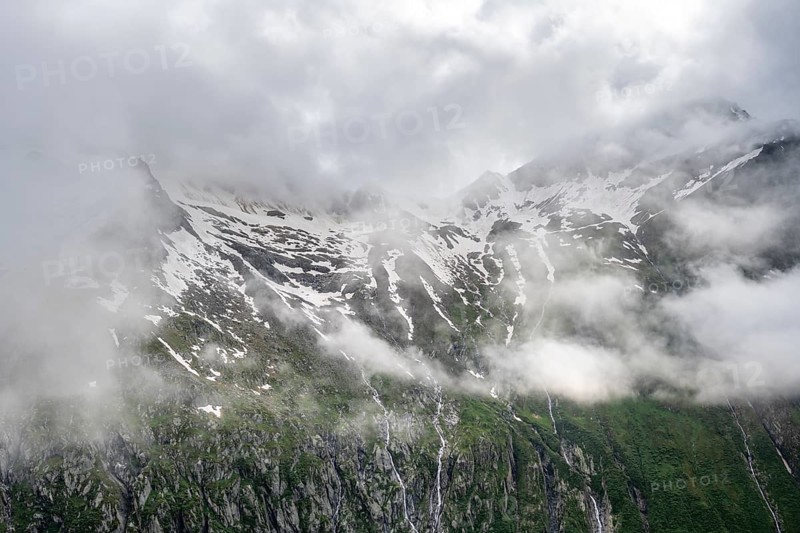Snow-covered cloudy mountains with summit Hochsteller, mountain streams as waterfalls on a mountainside, Furtschaglhaus, Berliner Hoehenweg, Zillertal, Tyrol, Austria, Europe