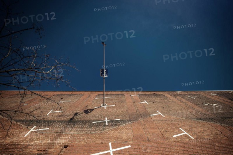 A lamppost and a car park sign in front of a brick wall with white lines, Cologne Deutz, North Rhine-Westphalia, Germany, Europe