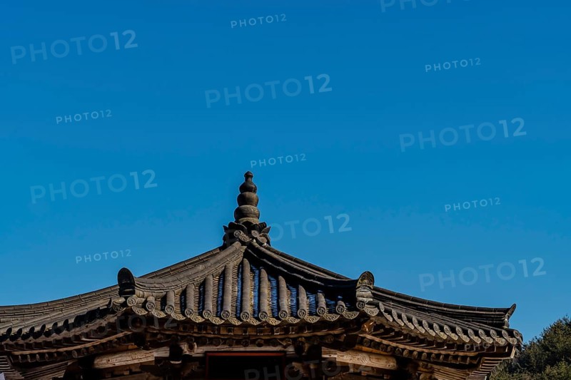 Tiled rooftop of oriental gazebo against clear blue sky
