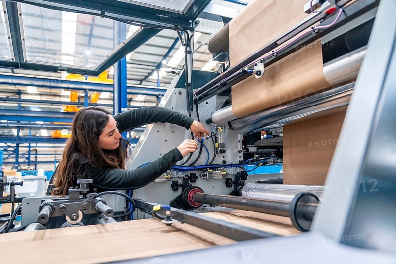 Side view with copy space of a Engineer working on a machine in a cnc modern factory