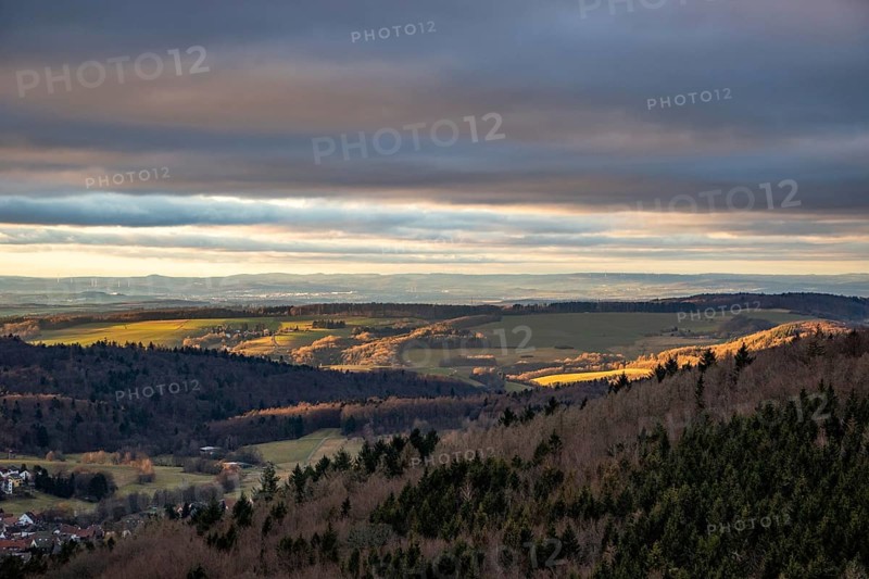Landscape at the Grosser Zacken, Taunus volcanic region. A cloudy, sunny autumn day, meadows, hills, fields and forests with a view of the sunset. Hesse, Germany, Europe