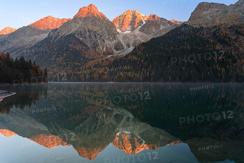 Mountains reflected in a mountain lake at sunrise, autumn, Lake Antholz, Rieserferner Group, South Tyrol, Italy, Europe