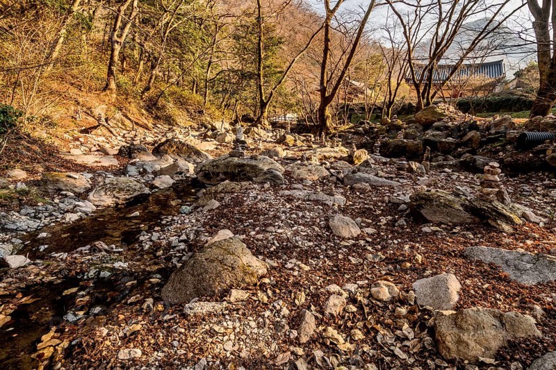 Pebble stacks in dry riverbed in mountain wilderness park