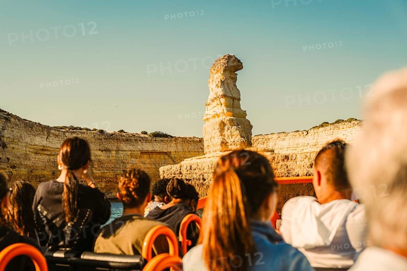 Tourist in the boat admiring rock formation called submarine, Albufeira, Algarve, south of Portugal