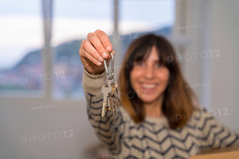 Happy woman showing the keys of a new house while moving