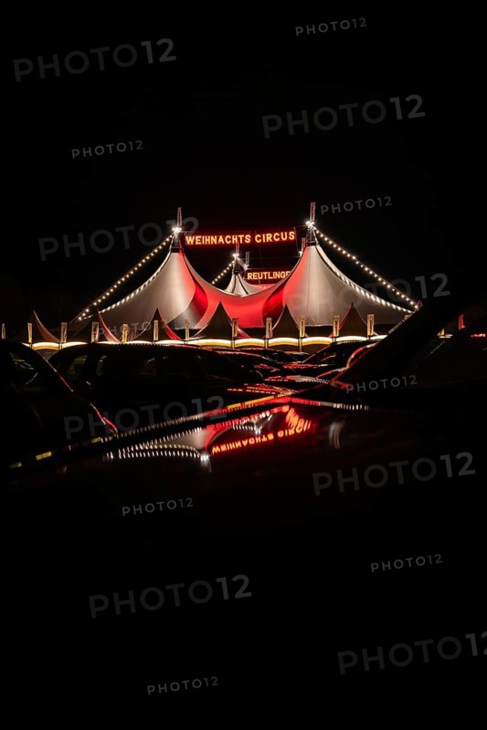 Tents of the 'Christmas Circus' with fairy lights mirrored on cars, Reutlingen, Germany, Europe