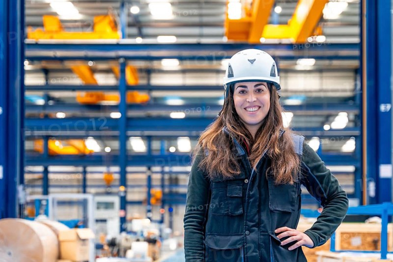 Portrait of a smiling female worker with protective gear standing in a logistic center