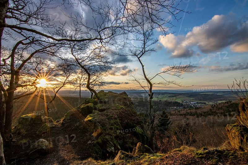 Landscape at the Grosser Zacken, Taunus volcanic region. A cloudy, sunny autumn day, meadows, hills, fields and forests with a view of the sunset. Hesse, Germany, Europe