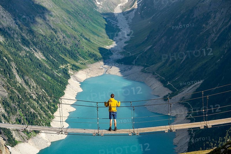 Mountaineers on a suspension bridge, picturesque mountain landscape near the Olpererhuette, view of turquoise-blue lake Schlegeisspeicher, Berliner Hoehenweg, Zillertal Alps, Tyrol, Austria, Europe