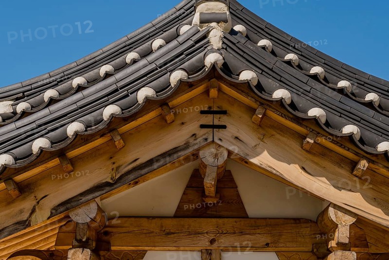 Closeup low angle view of ceramic tiled roof on oriental gate at public park
