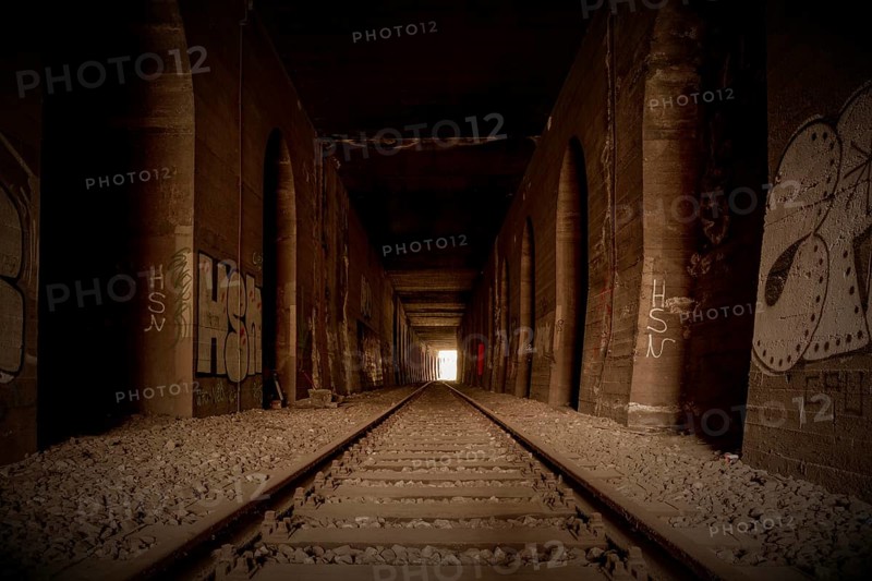 An abandoned railway tunnel, symmetrical with rails and side walls full of graffiti, former Rethel railway branch, Lost Place, Flingern, Duesseldorf, North Rhine-Westphalia, Germany, Europe